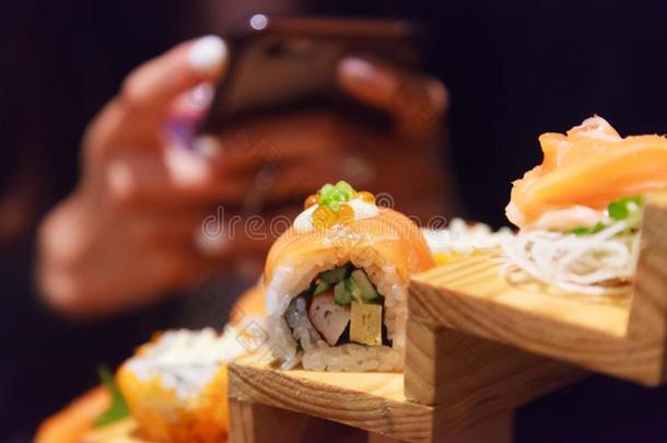 女人使用智能手机拿照片向日本人新鲜的<strong>鱼食</strong>物,Semi-ActieLaster半主动激光器