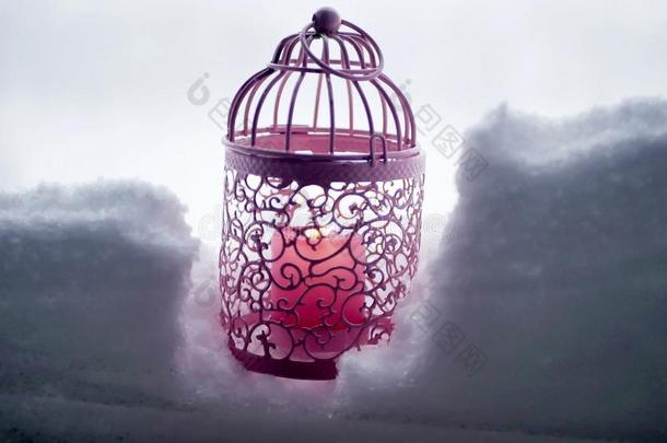 粉红色的装饰的灯笼和一燃烧的c一ndle采用指已提到的人雪一g一采用s