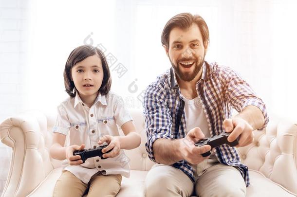 有胡须的父亲和儿子演奏计算机游戏使用游戏<strong>控件</strong>