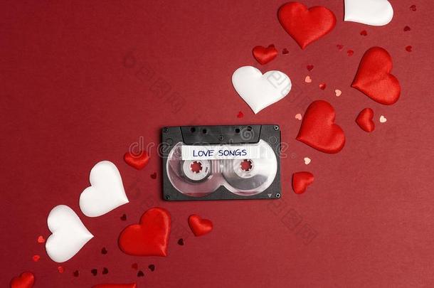 听觉的盒式录音带带子和爱歌曲和心向红色的背景