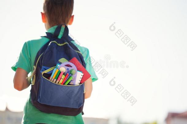 男孩和满的学校背包.小的学生出行背向学校