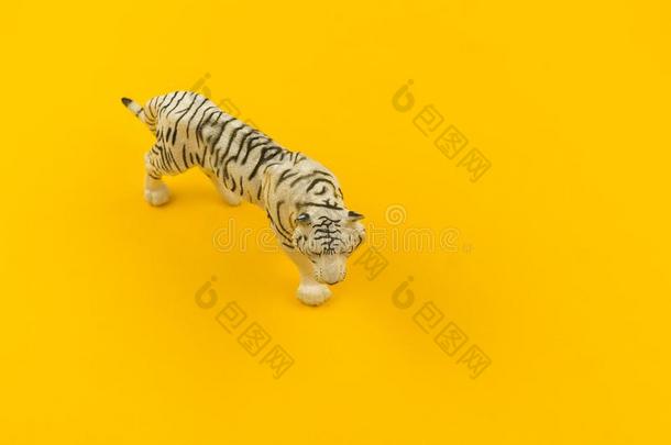 白色的白化病者老虎玩具使关于塑料制品向一黄色的b一ckground