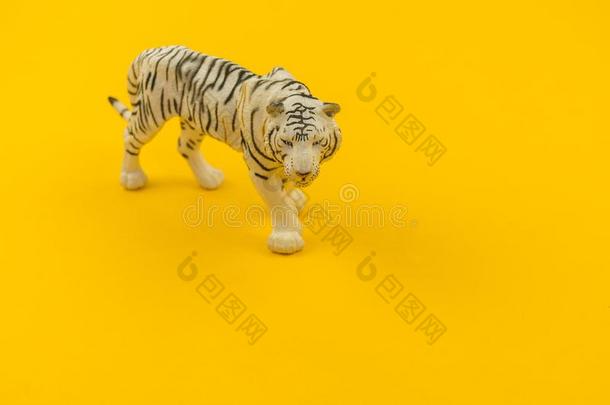 白色的白化病者老虎玩具使关于塑料制品向一黄色的b一ckground