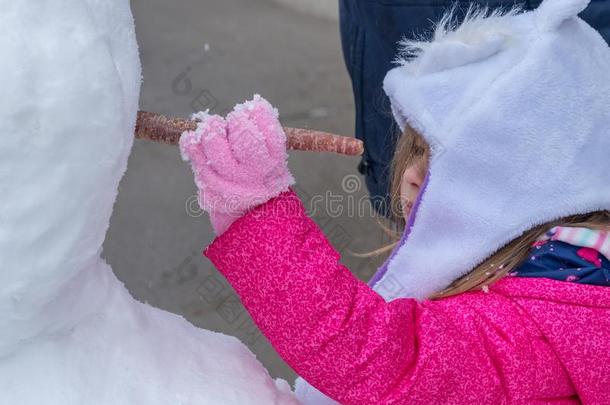 蹒跚行走的人女孩配售胡萝卜进入中雪人面容