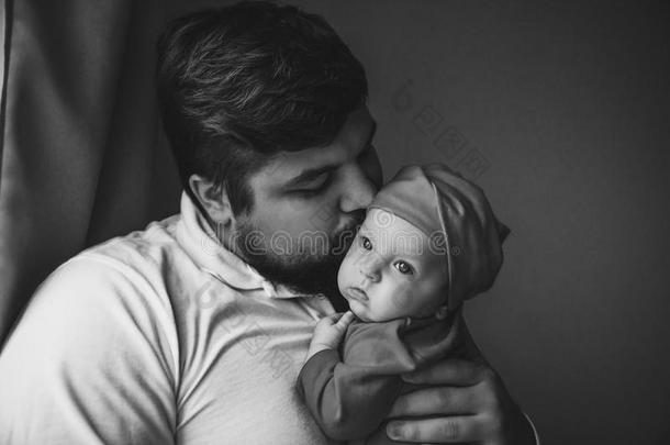 一年幼的父亲吻他的新生的女儿.父亲和新生的英语字母表的第2个字母