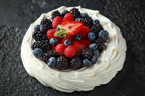 浆果奶油水果蛋白饼蛋糕和新鲜的越橘的一种,草莓和以粗锉打磨
