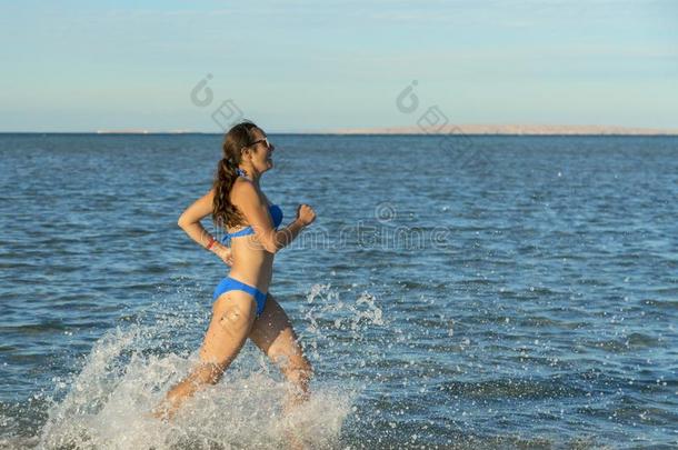 一年幼的黑头发的妇女女人或女孩使人疲乏的一比基尼式<strong>游泳</strong>衣跑步<strong>通过</strong>