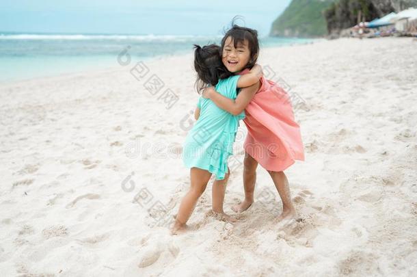 肖像关于两个小的女孩热烈地拥抱向指已提到的<strong>人海</strong>滩