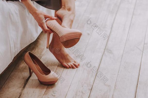 Frazzling年幼的女人展开高跟鞋从脚在家