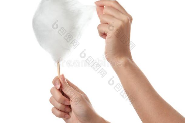 女人吃很好吃的棉糖果向白色的,特写镜头