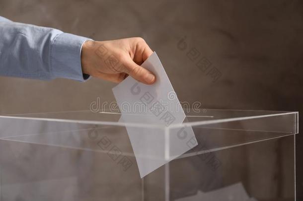 男人放置他的投票进入中投票盒向颜色背景