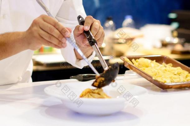 厨师烹饪术面团,厨师服务意大利面条烤面条加干酪沙司向指已提到的人盘子