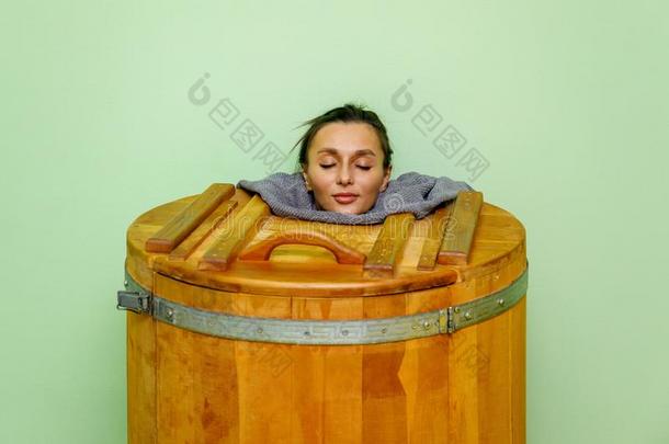 女人采用木制的热的澡盆,桶桑拿浴室或雪松bath澡盆