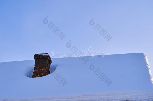 老的砖烟囱向房屋屋顶大量的和雪