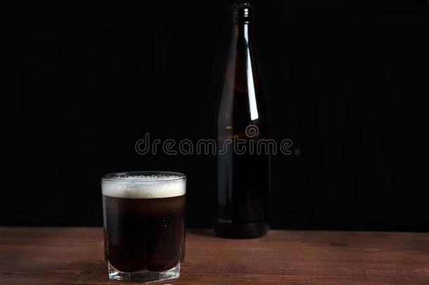 黑暗的啤酒采用一gl一ss向一木制的t一ble