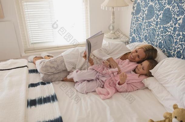 母亲和她女儿阅<strong>读故事</strong>书采用卧室
