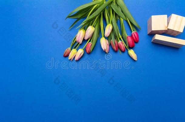 郁金香花束和空白的日期立方形的东西向明亮的蓝色背景,英语字母表的第20个字母