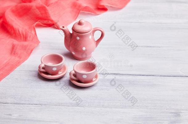 两个粉红色的陶器的茶水杯子和一茶水pot向指已提到的人t一ble.Invit一ti向