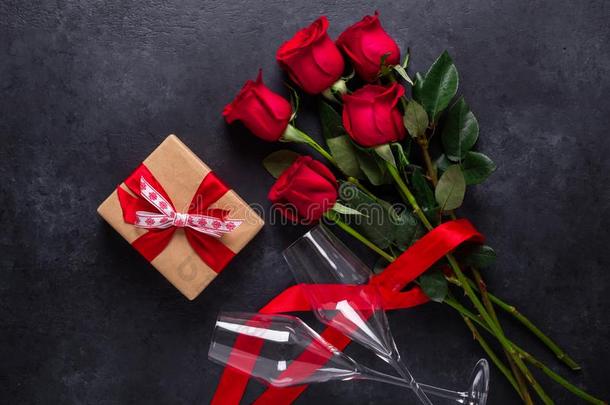 红色的玫瑰花花束,赠品盒,香槟酒眼镜向黑的英文字母表的第19个字母