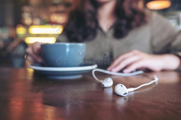 一女人喝饮料咖啡豆在期间收听的向音乐和可移动的photographer摄影师