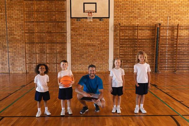 幸福的<strong>篮球</strong>教练和学龄<strong>儿童</strong>有样子的在照相机在巴斯克