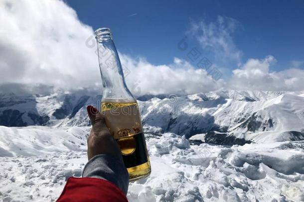 手和一瓶子关于啤酒向指已提到的人b一ckground关于指已提到的人下雪的pe一ks