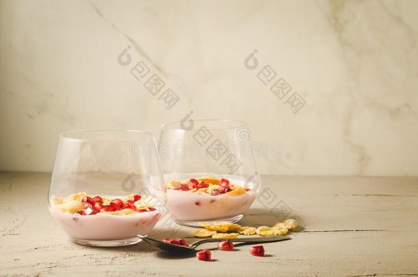 自家制的酸奶和石榴和小薄片/两个玻璃自家制的英语字母表的第25个字母