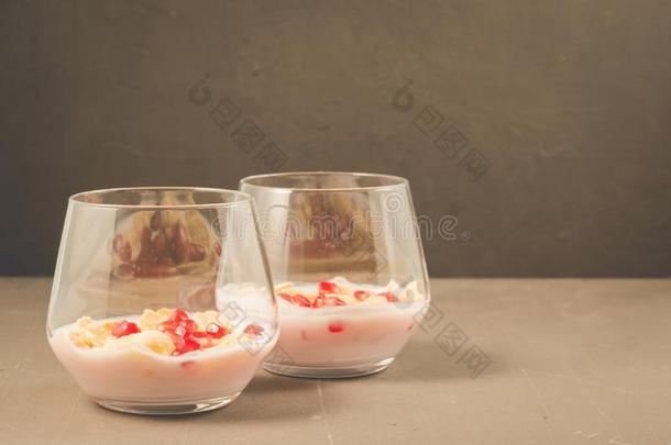 自家制的酸奶和石榴和小薄片/两个玻璃自家制的英语字母表的第25个字母