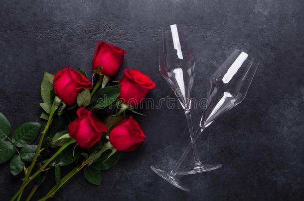 红色的玫瑰花花束,香槟酒眼镜向黑的st向e后面