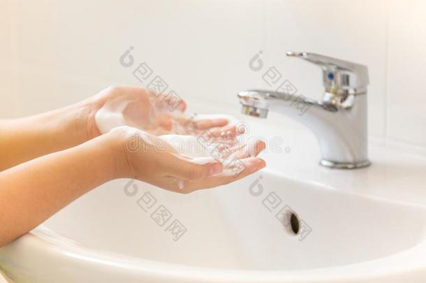 孩子们洗涤手和起泡沫肥皂采用浴室s采用k