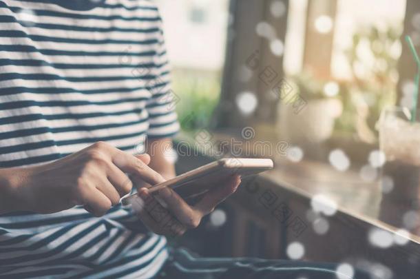 女人手使用智能手机和便携式电脑和咖啡馆商店阳<strong>光英文</strong>字母表的第19个字母