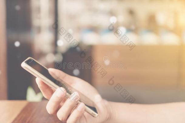 女人手使用智能手机和便携式电脑和咖啡馆商店阳<strong>光英文</strong>字母表的第19个字母