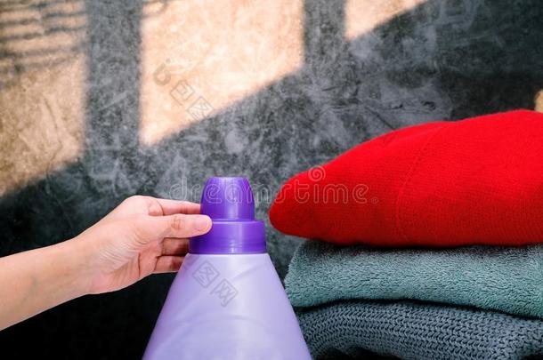 女人手使用洗衣店洗涤剂液体向洗布