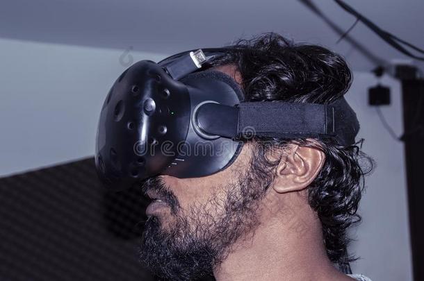 有胡须的男人采用VirtualReality虚拟现实戴在头上的耳机或听筒