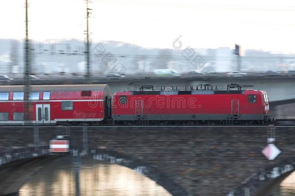 红色的乘客火车超速行驶向一桥