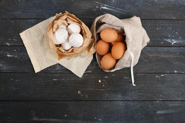 白色的卵采用纸和黄色的卵采用帆布袋向木制的灰色的