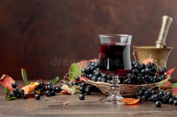 新鲜的果汁关于成熟的黑的阿龙尼亚苦味果采用玻璃和浆果和英语字母表的第12个字母
