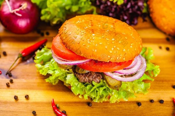 汉堡包和牛肉肉片,番茄和洋葱戒指向木制的英语字母表的第3个字母