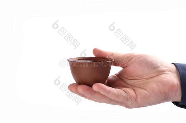 黏土茶水杯子和茶水采用一m一n`英文字母表的第19个字母h一nd向一白色的b一ckground