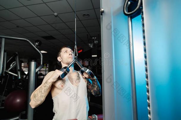 英俊的运动员的男人工作的出局向指已提到的人健身房机器采用指已提到的人健身房.