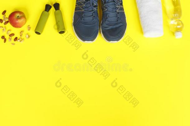 运动鞋子,暂时把货物腾空粗绳,苹果和瓶子关于水向黄色的