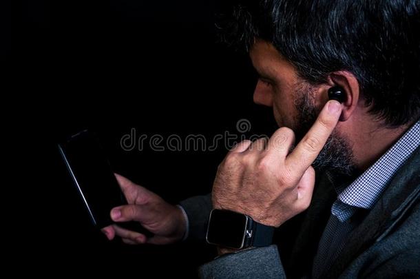 男人使用智能手机和智能手表连接的向不用电线的耳机