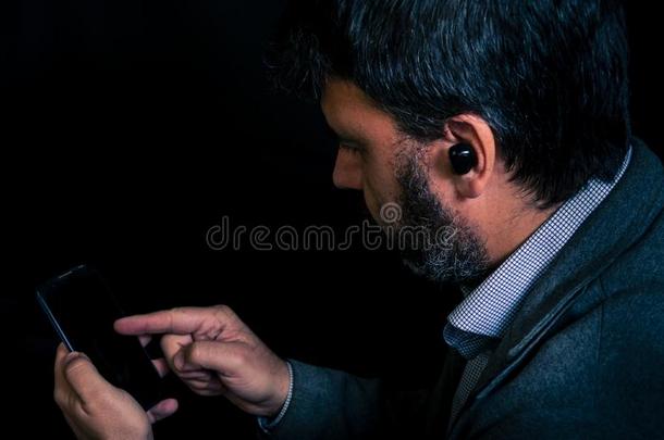 男人使用智能手机和蓝牙耳机
