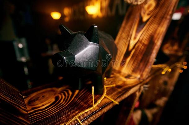 黑的猪小雕像看台向一黄色的木制的架子