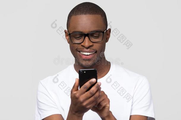 幸福的年幼的非洲的男人使用智能手机小玩意社会的媒体计算机应用程序