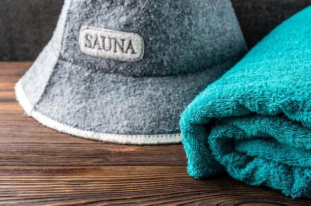 桑拿浴室帽子和毛巾向黑暗的木制的背景.沐浴附件.