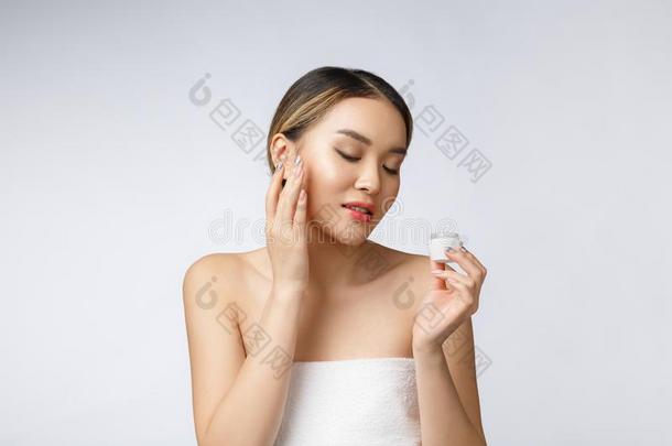 亚洲人女人应用化妆品乳霜向皮向隔离的白色的波黑