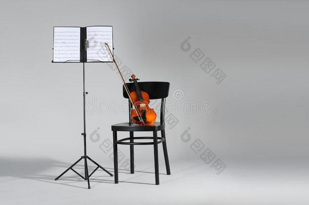 小提琴,椅子和笔记st和和音乐纸向灰色的后座