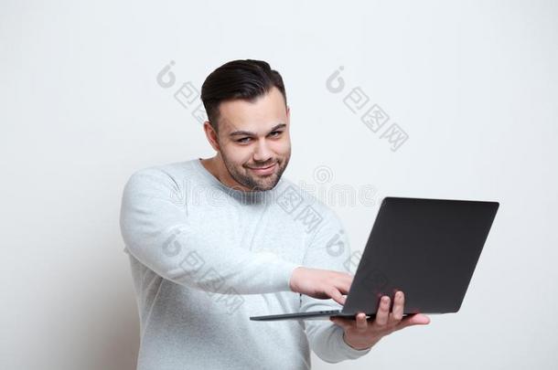 肖像关于年幼的男人打字向便携式电脑键盘越过白色的后面