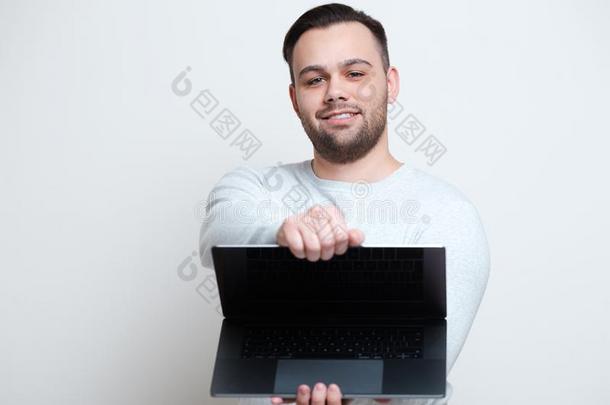 肖像关于年幼的幸福的男人开幕便携式电脑越过白色的背景